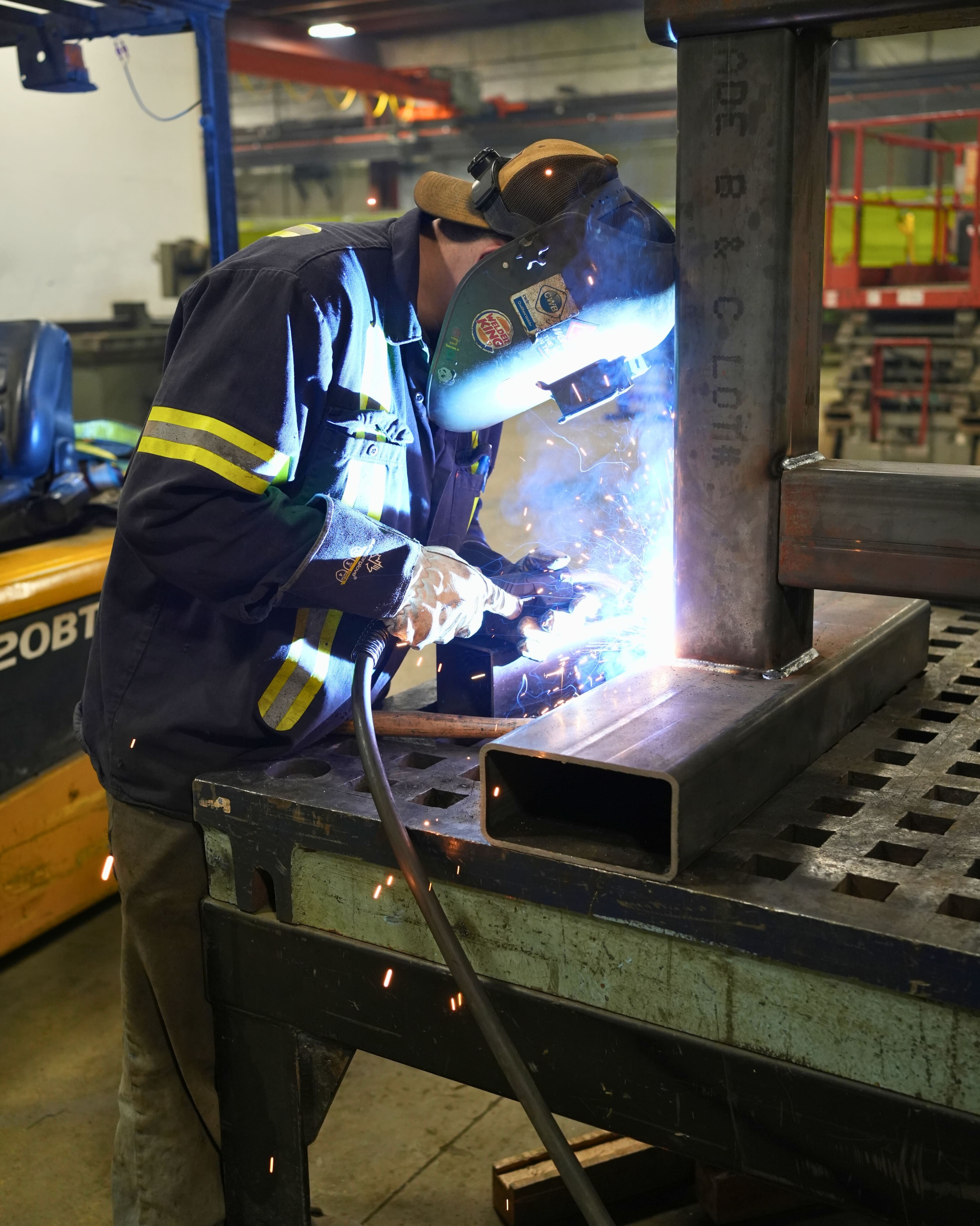 Construction worker welding with safety equipment on job site