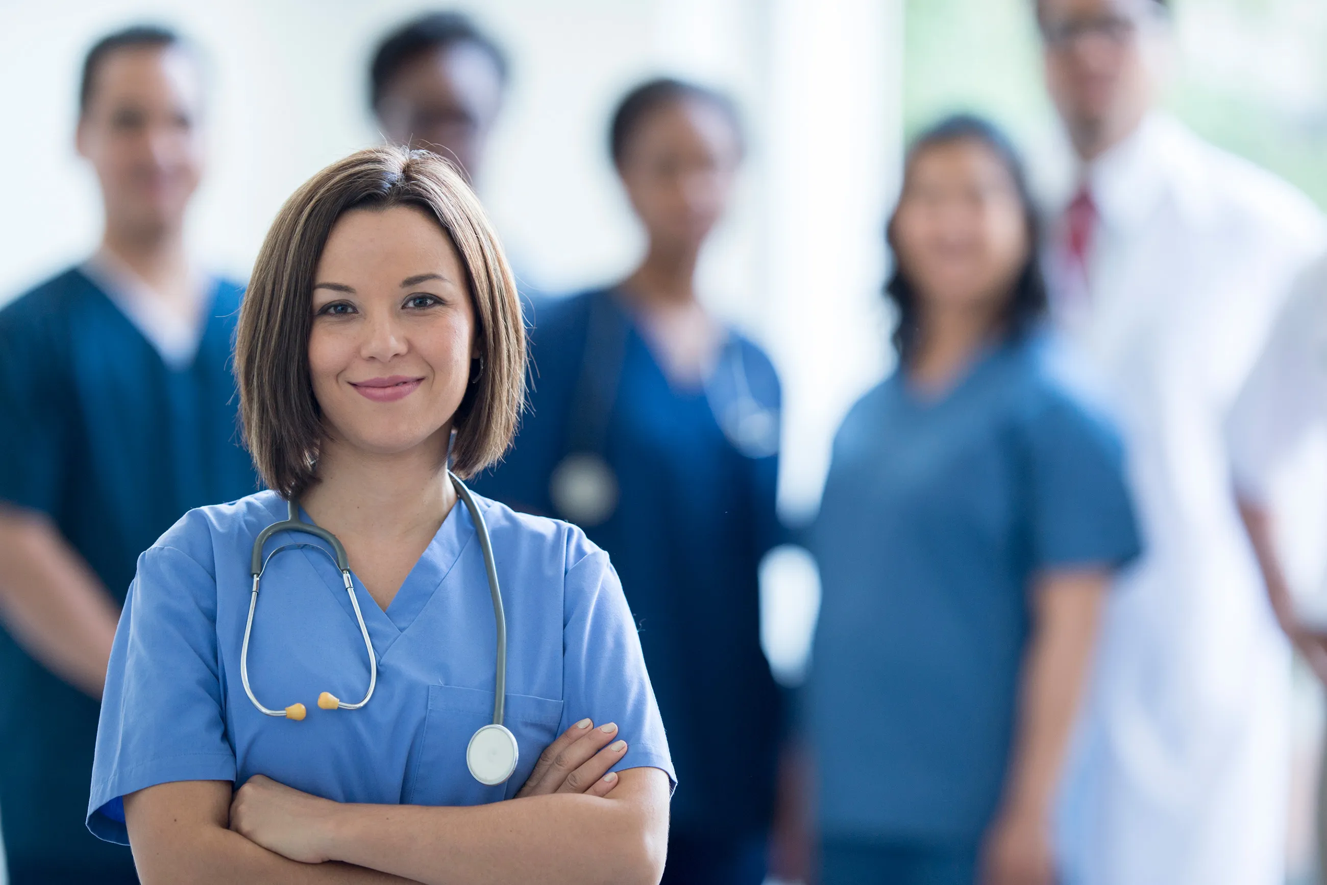 A female nurse standing in front of a group of her colleagues