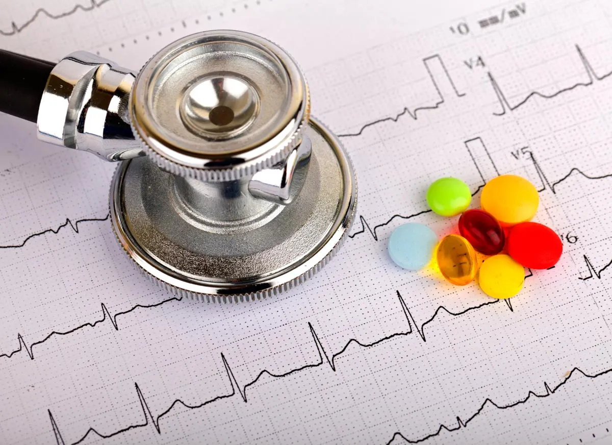 A stethoscope and medication placed on cardiogram results