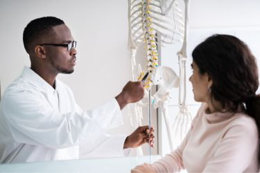 Chiropractor explaining to a patient where the pain is coming from