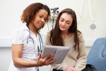 Medical assistant with a tablet educating her patient.