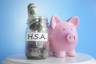 Piggy bank next to a Jar that says H.S.A (Health Savings Account)
