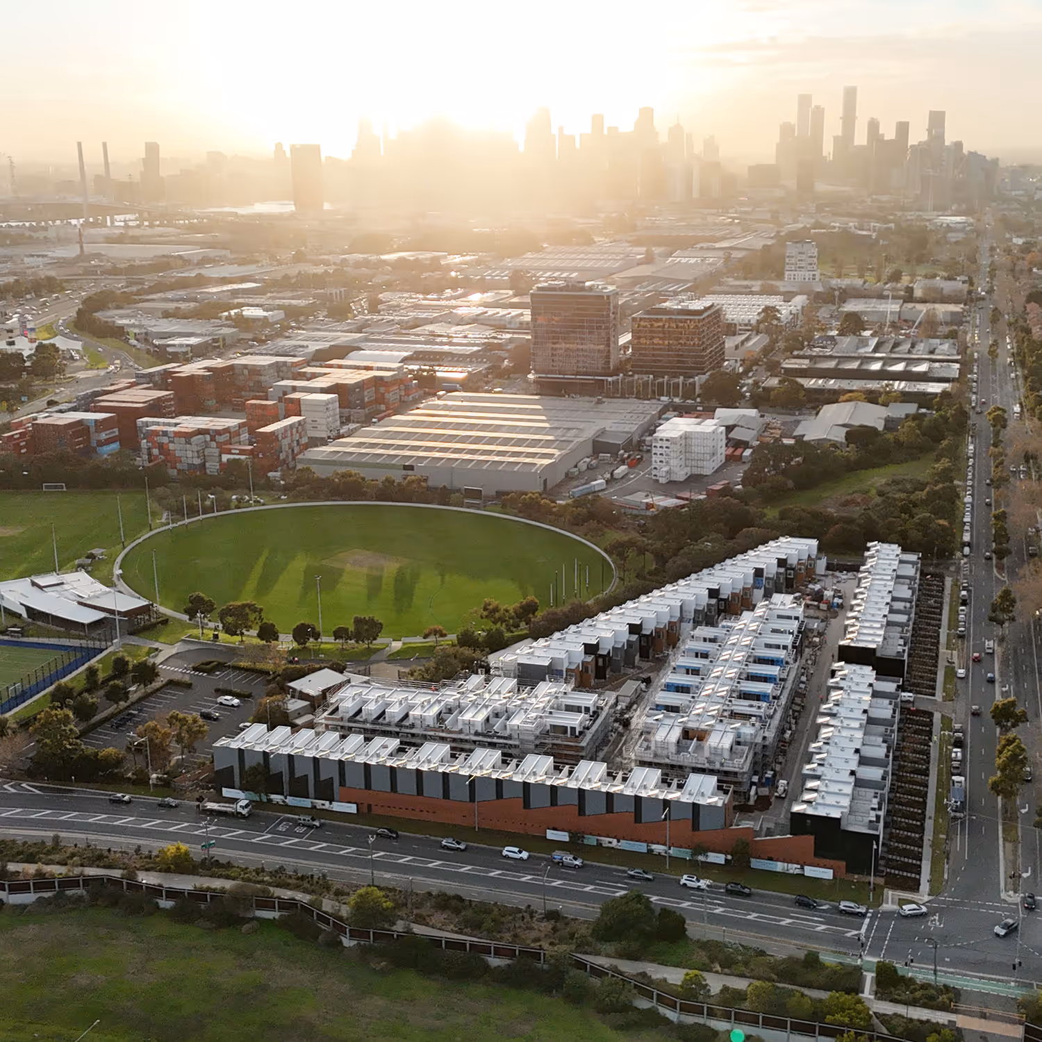 Aerial view of a city in the distance with parks and houses in the foreground