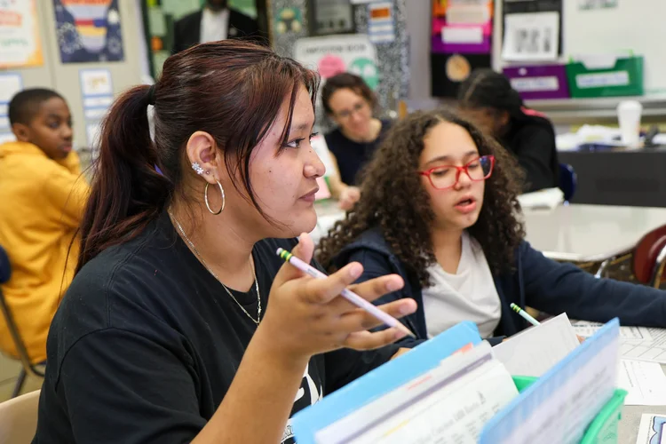 Student gesturing while speaking during a classroom discussion