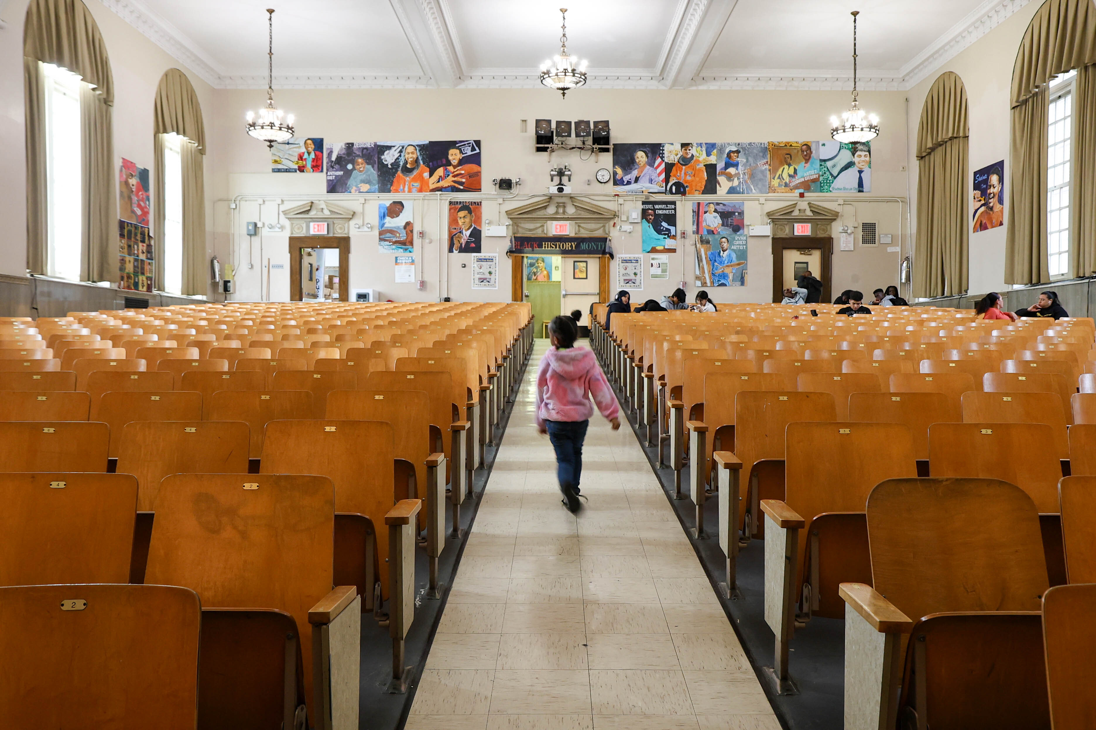 Student walking through school auditorium decorated with Black History Month posters