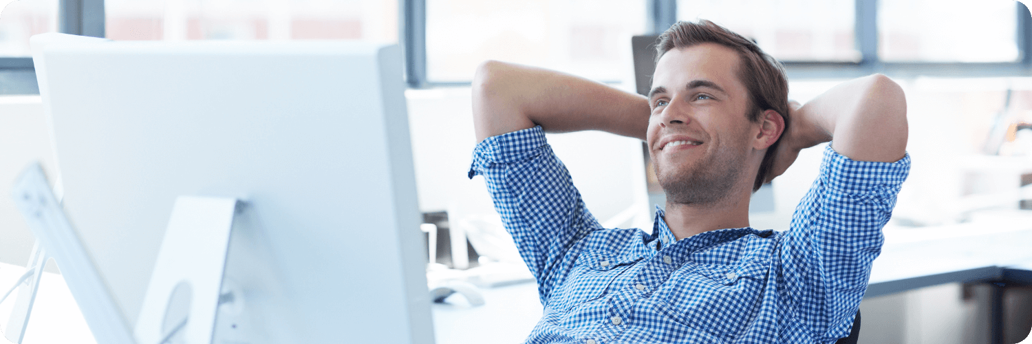 Un homme détendu face à son ordinateur représentant que l’automatisation de l’accrochage certificateur simplifie la vie aux organismes.