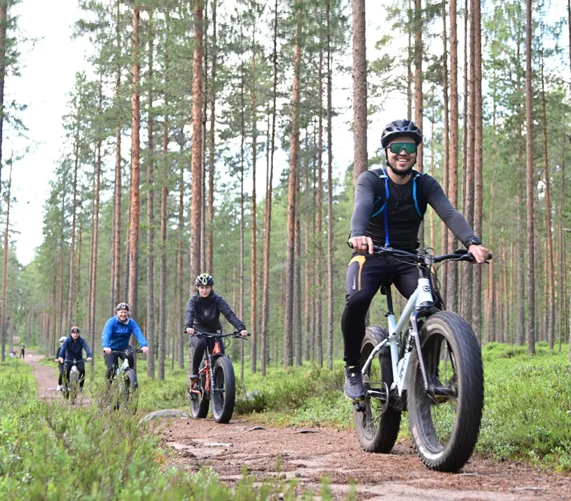 Ryhmä sähköfatbike-pyöräilijöitä retkellä metsäpolulla Oulussa