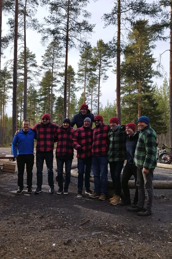 Ryhmä iloisia ihmisiä kävelemässä metsäpolulla