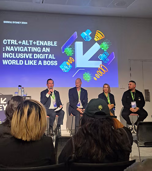 Panel of four speakers seated on a stage at SXSW Sydney 2024 with a presentation slide that reads 'CTRL+ALT+ENABLE: Navigating an inclusive digital world like a boss.'