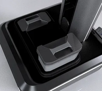 Close-up of a black and gray modern stapler placed on a flat surface.