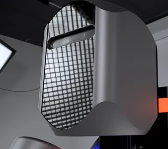 Close-up of a sleek, modern computer tower with reflective mesh and curved metallic surfaces in a dark environment.