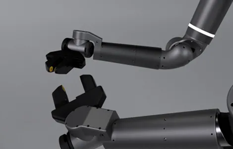 Close-up of a black robotic arm with a claw-like gripper against a gray background.
