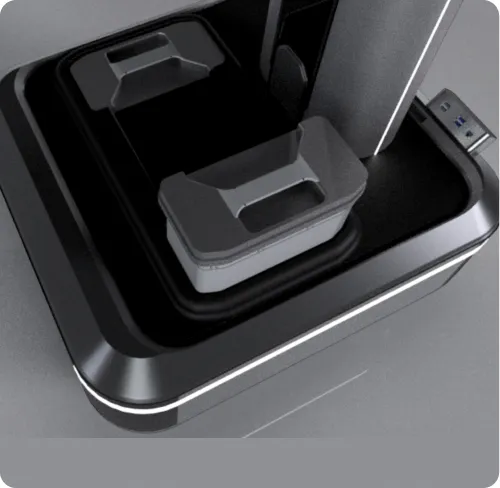 Close-up of a black and gray electronic device with a USB port on a gray surface.