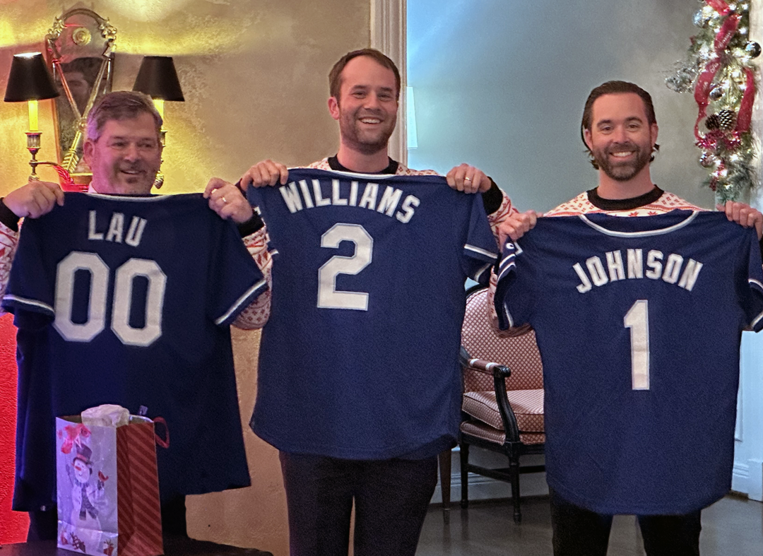 DPLFP team members holding sports jerseys and smiling.
