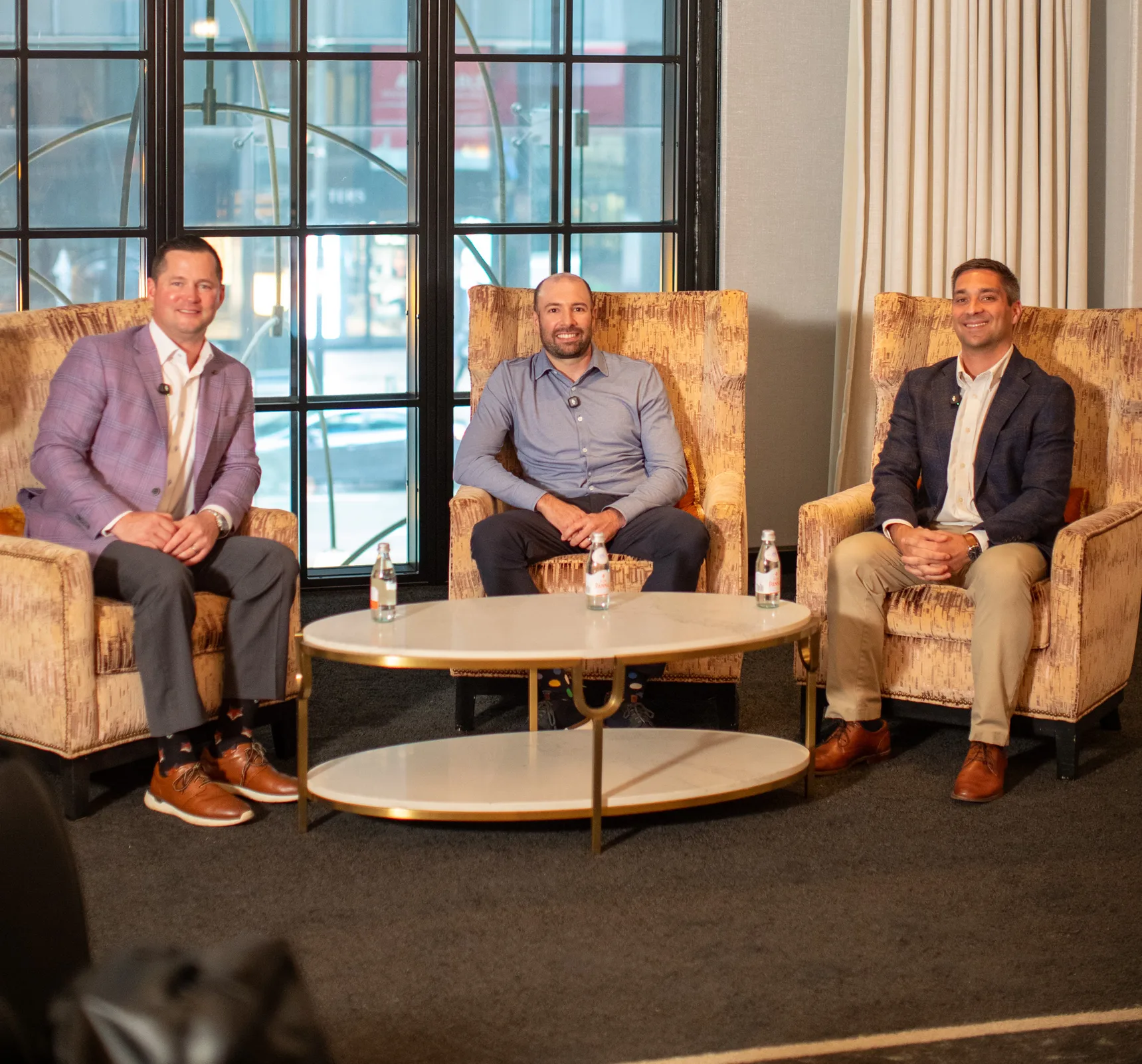 Three DPL team members seated in armchairs during a panel discussion