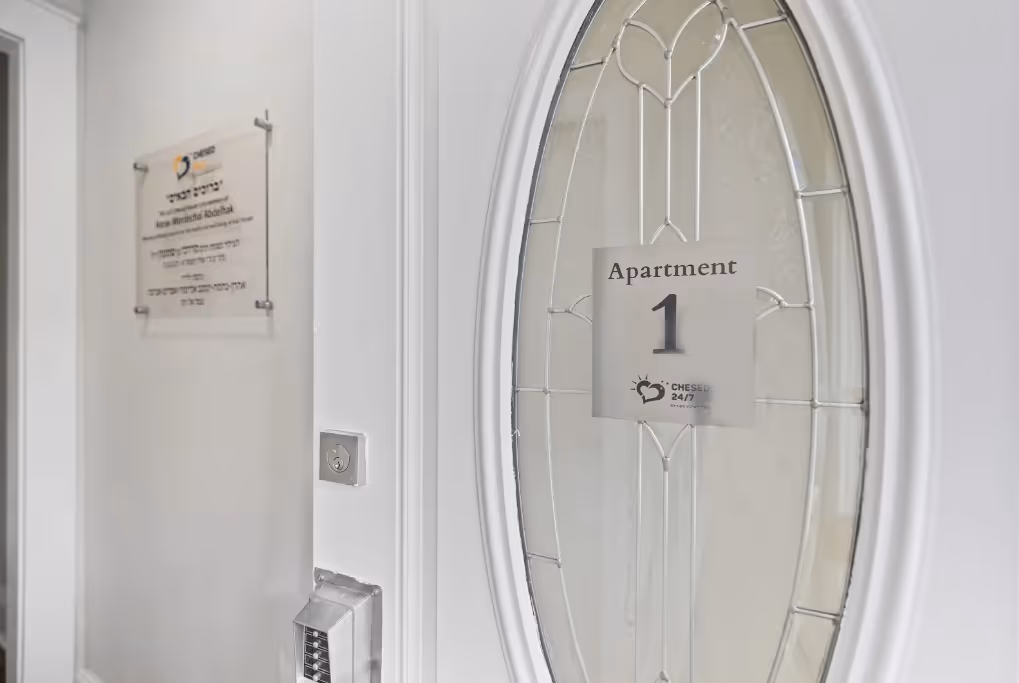 Entrance door of the Chesed 24/7 Hackensack hospital apartment, marked “Apartment 1,” providing free family lodging near Hackensack Medical Center