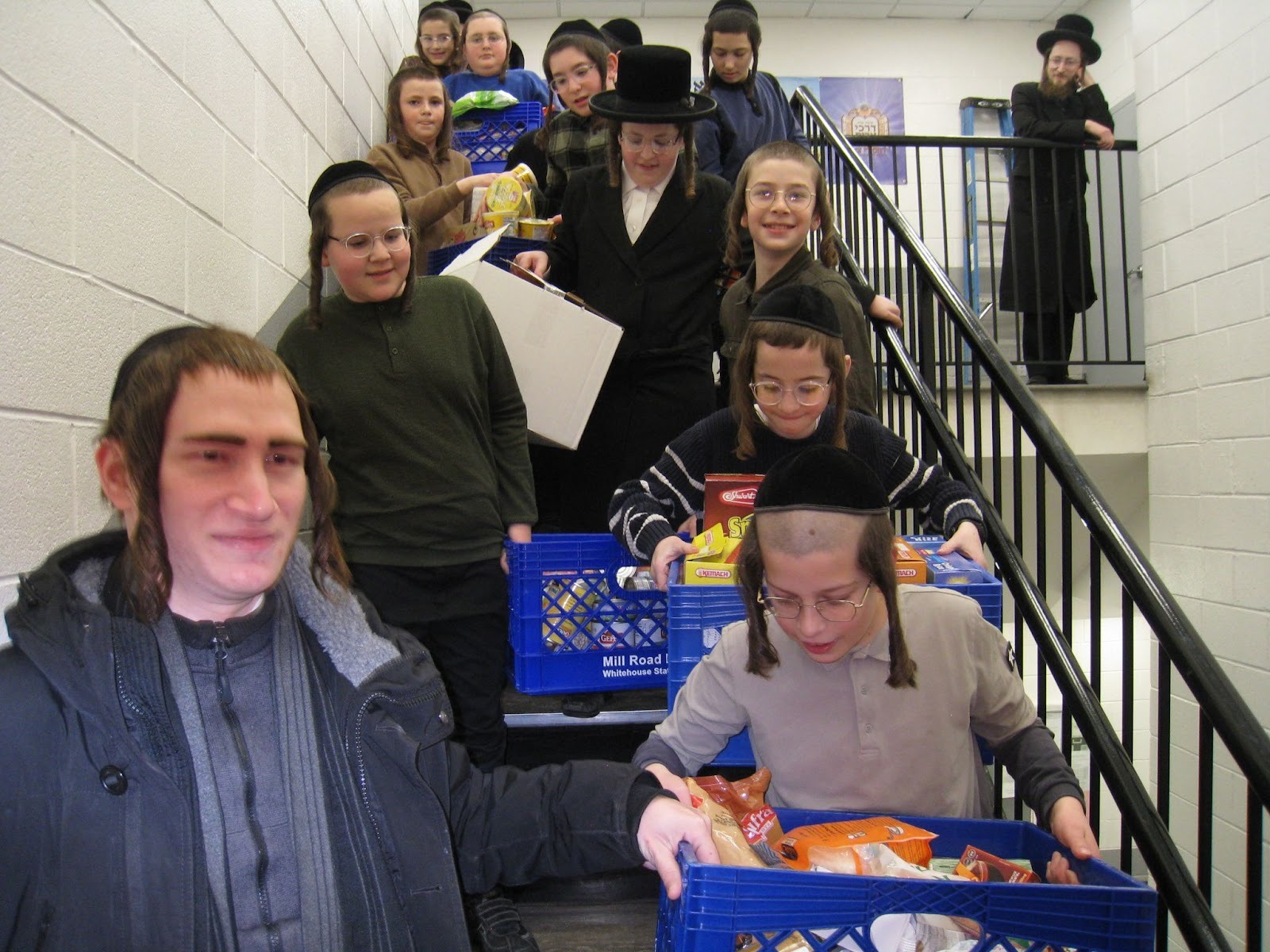 boys carrying crates of food to stock chesed 247 hospitality room pantries