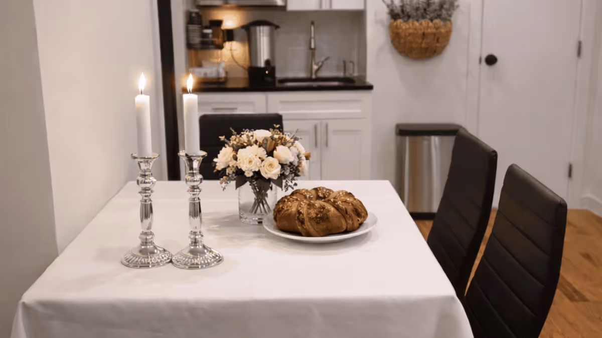 Shabbos table with candles and challah in a Chesed 24/7 hospital hospitality apartment
