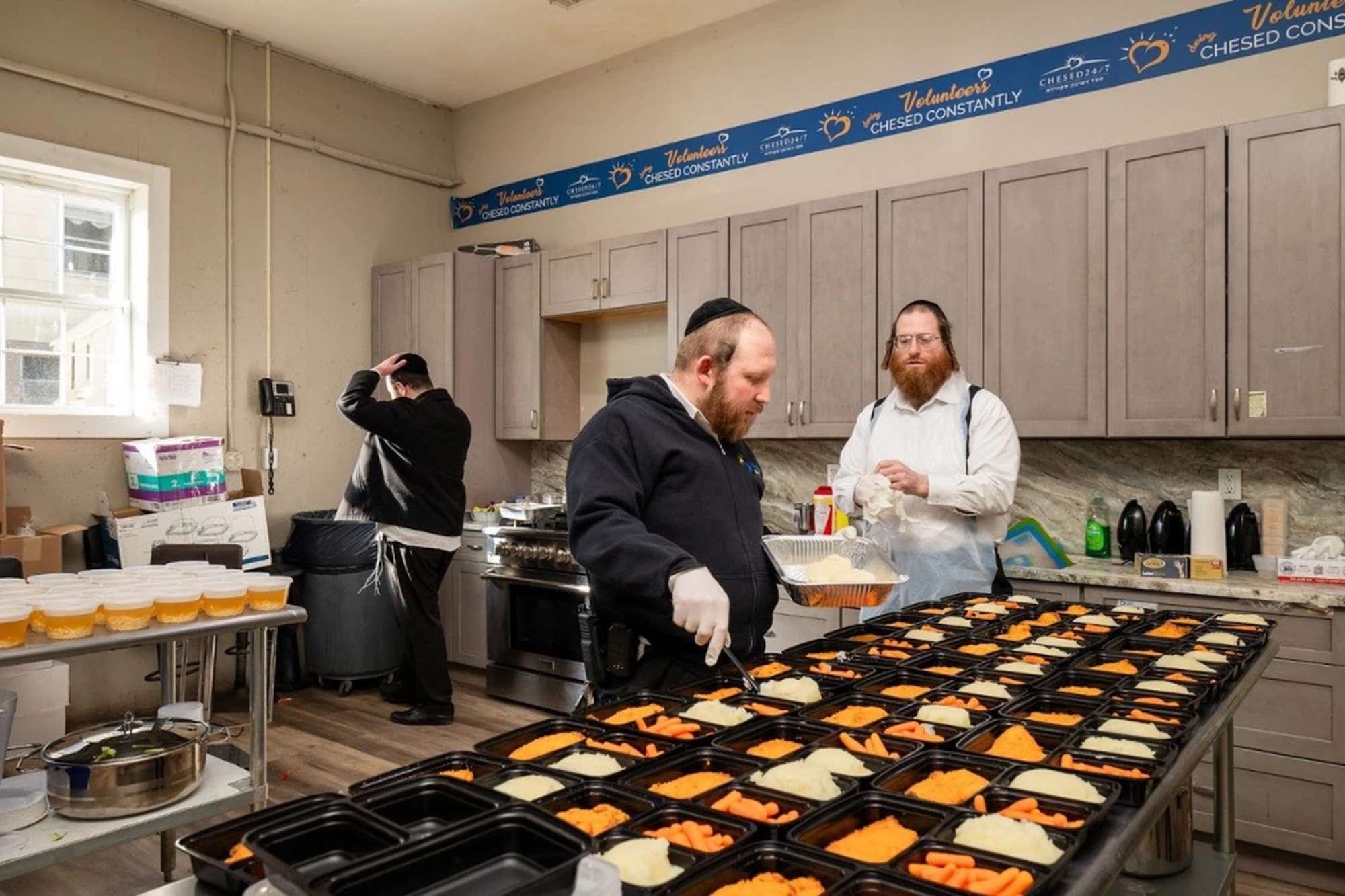 Chesed 24/7 volunteers preparing fresh kosher meal trays with carrots rice and sides in the organization kitchen for bedside delivery to hospital patients across New York and New Jersey