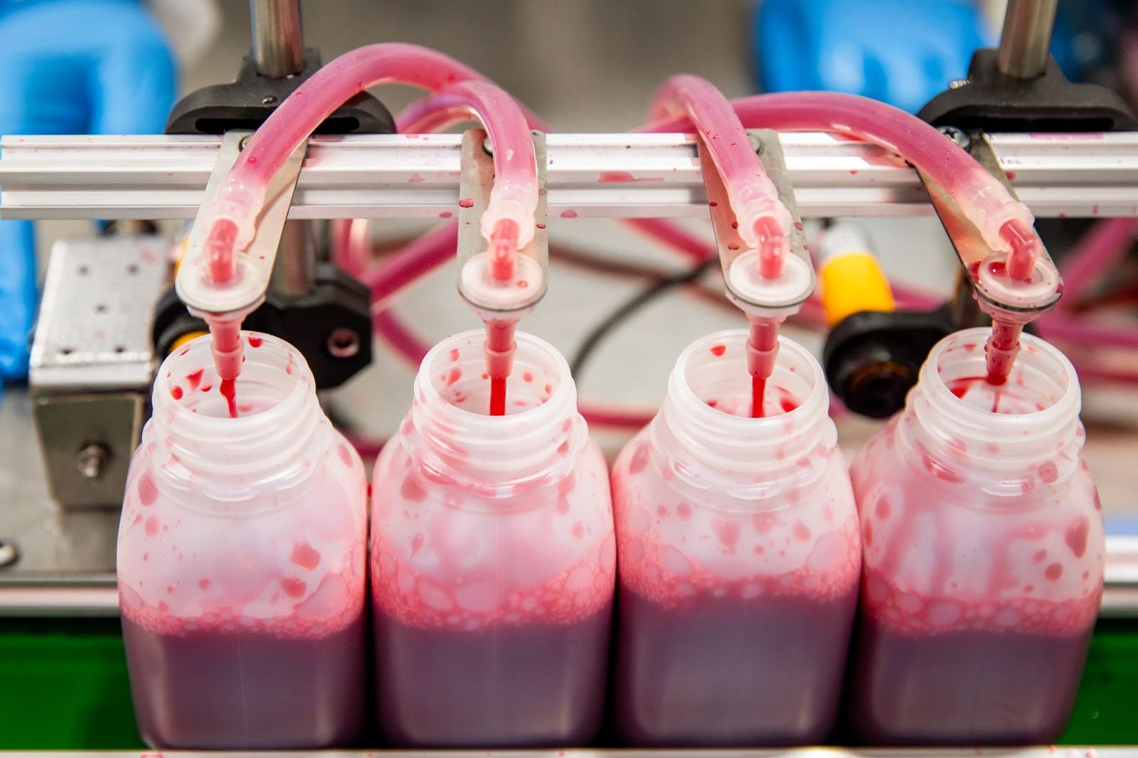 bottles filling with pom juice via factory machinery