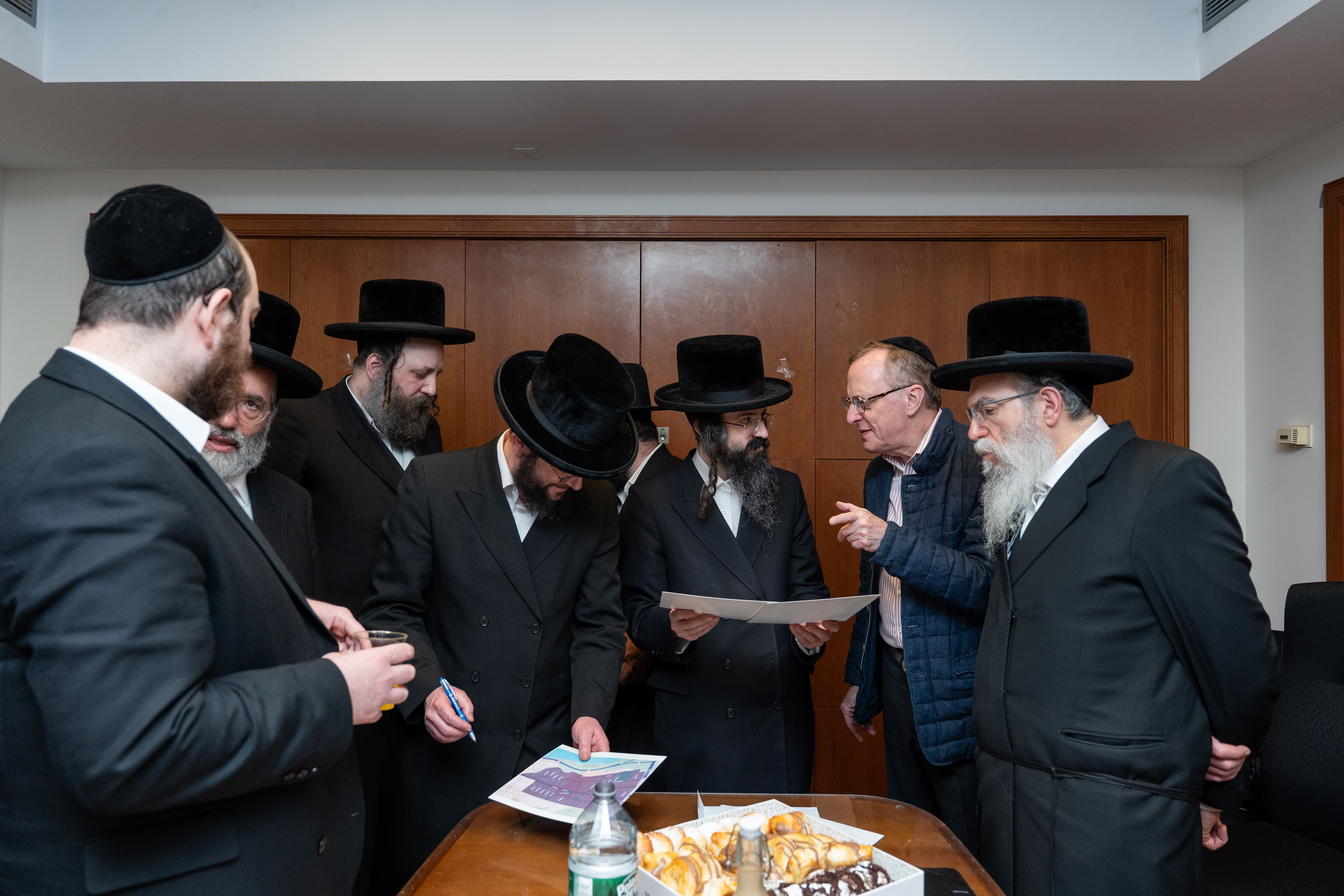 Rabbanim and hospital representatives reviewing plans at Columbia Hospital Eiruv inauguration with Chesed 24/7
