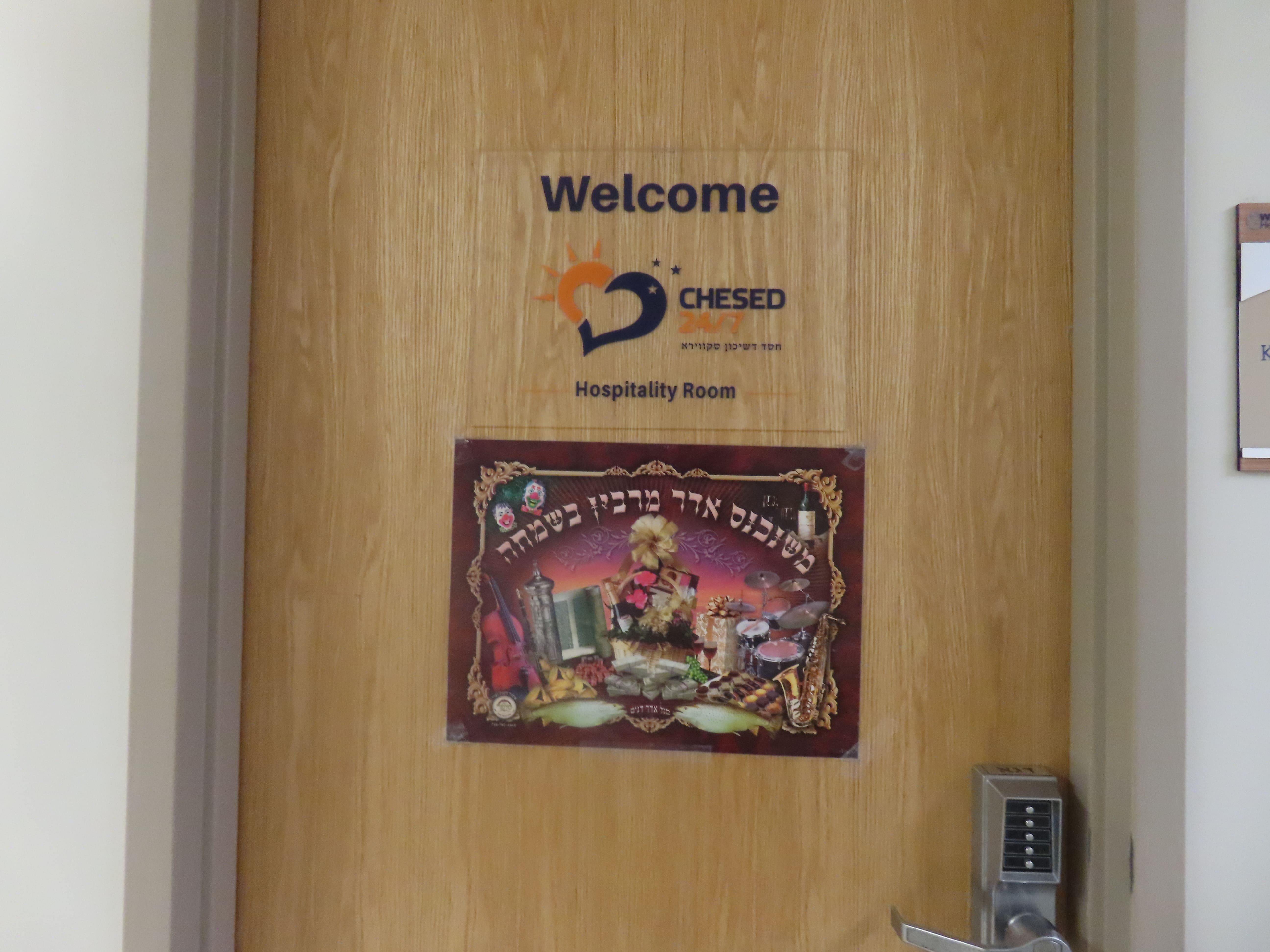 Chesed 24/7 hospitality room entrance decorated for Purim with festive signage