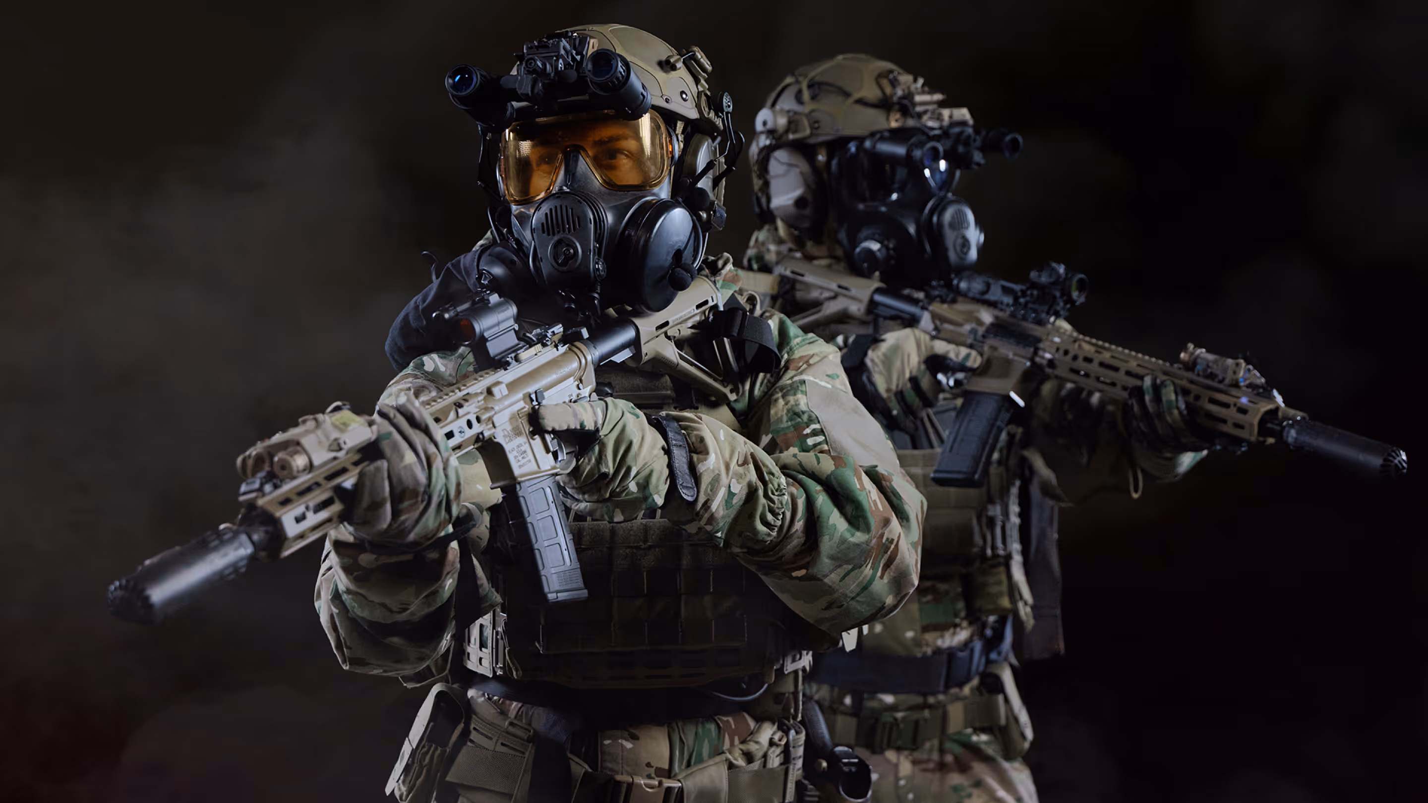 Two soldiers in camouflage uniforms and tactical gear aiming rifles against a dark background.