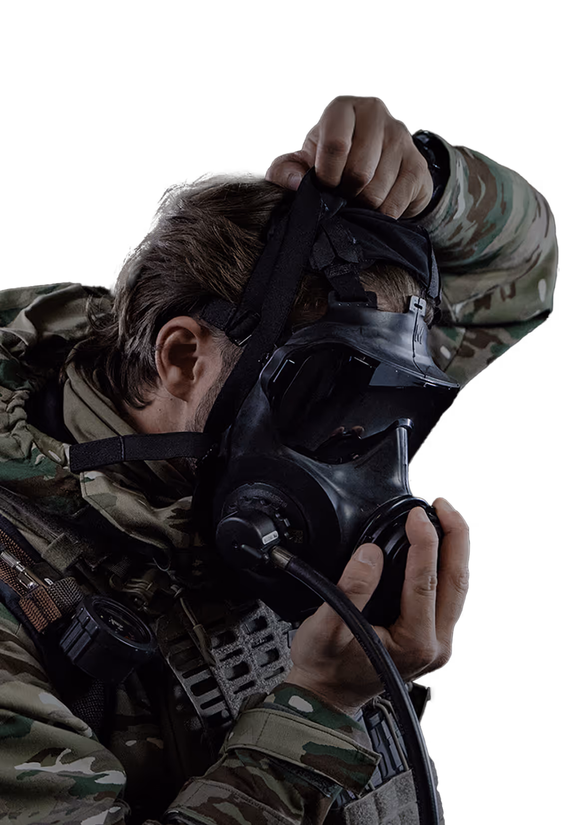 Person in camouflage putting on a black gas mask with attached hose.