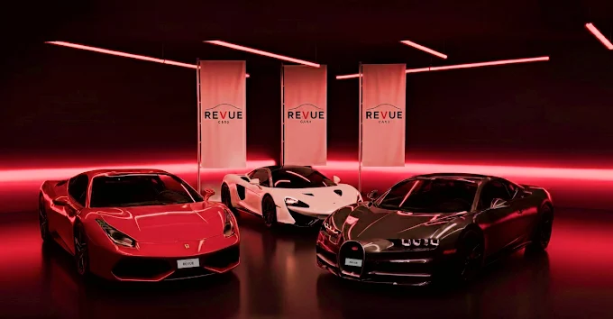 Red Ferrari, white McLaren, and black Bugatti sports cars displayed indoors with red neon lighting and Revue brand banners in the background.