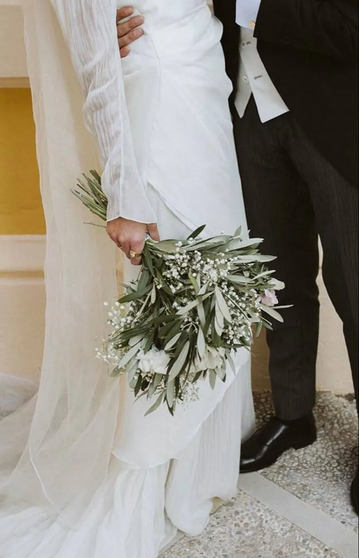 A bride holding a bouquet and a groom.