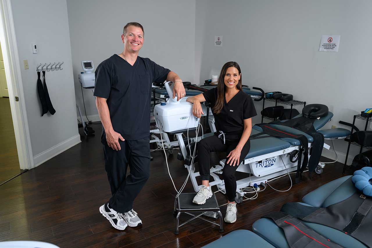 Dr. Scott and Dr. Dana LeBlanc with one of their spinal decompression tables.