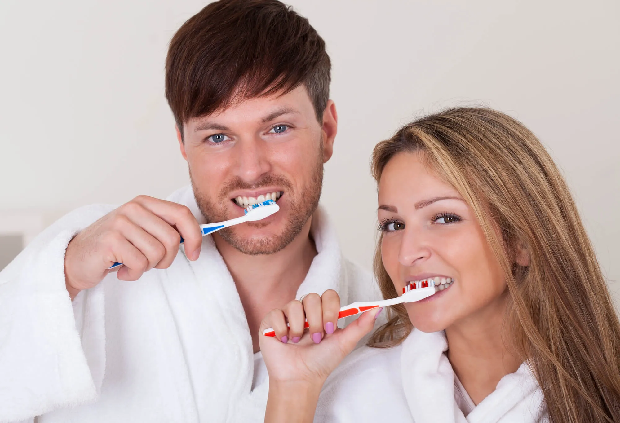 A couple brushing their teeth to maintain a deep teeth cleaning in Fort Lauderdale, FL 