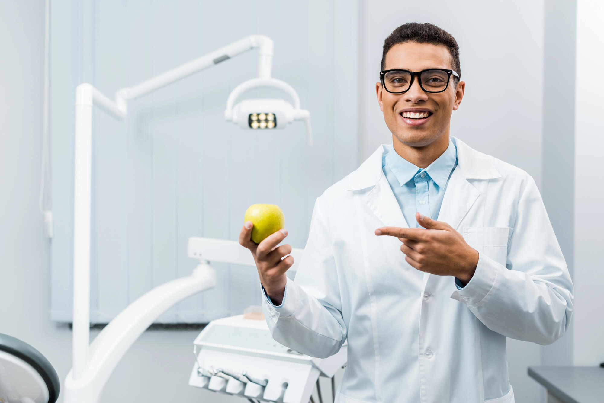 the best dentist in plantation fl holding an apple