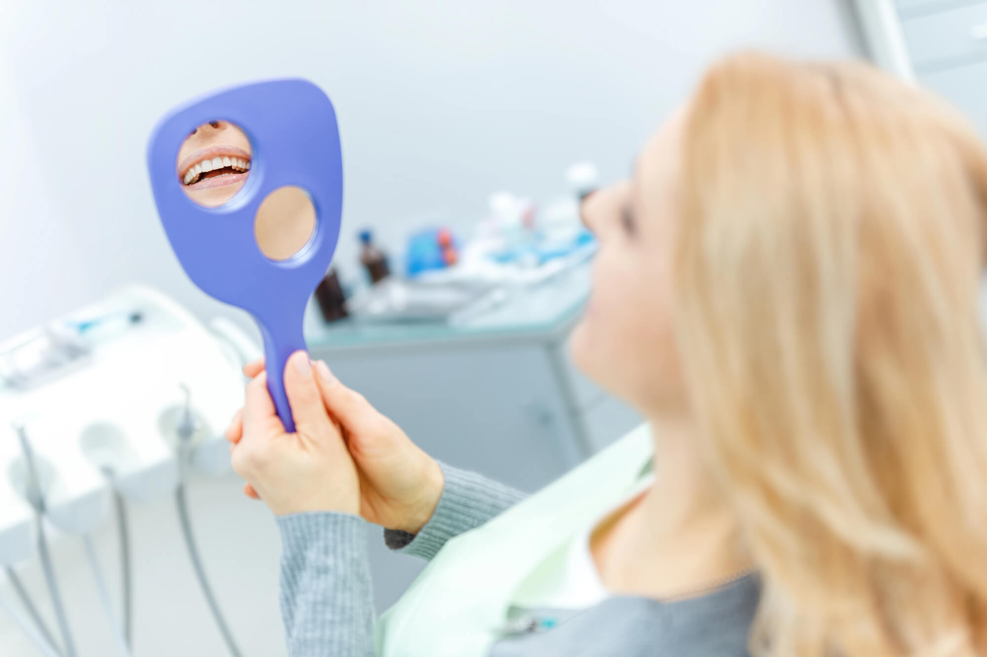 woman looking in the mirror at a dental office in plantation fl