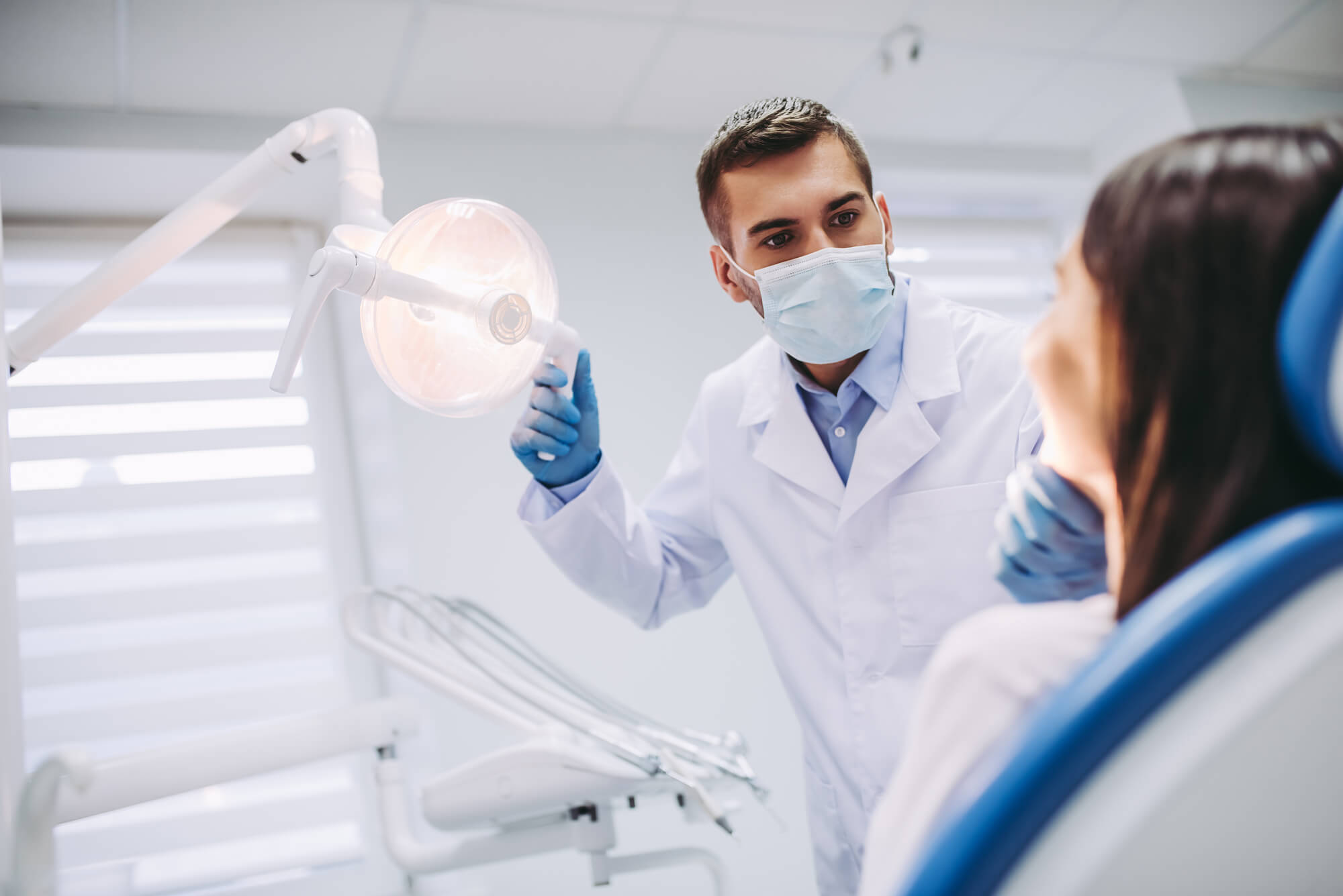 dentist checks patient's mouth after performing an emergency dentistry in Plantation, FL