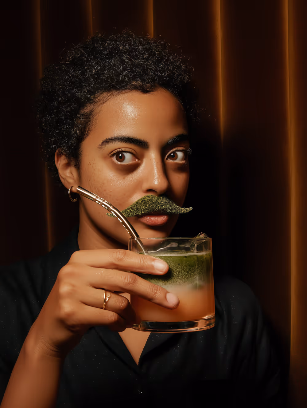 Young woman holding a frosted matcha glass in her hand for a beverage moment.