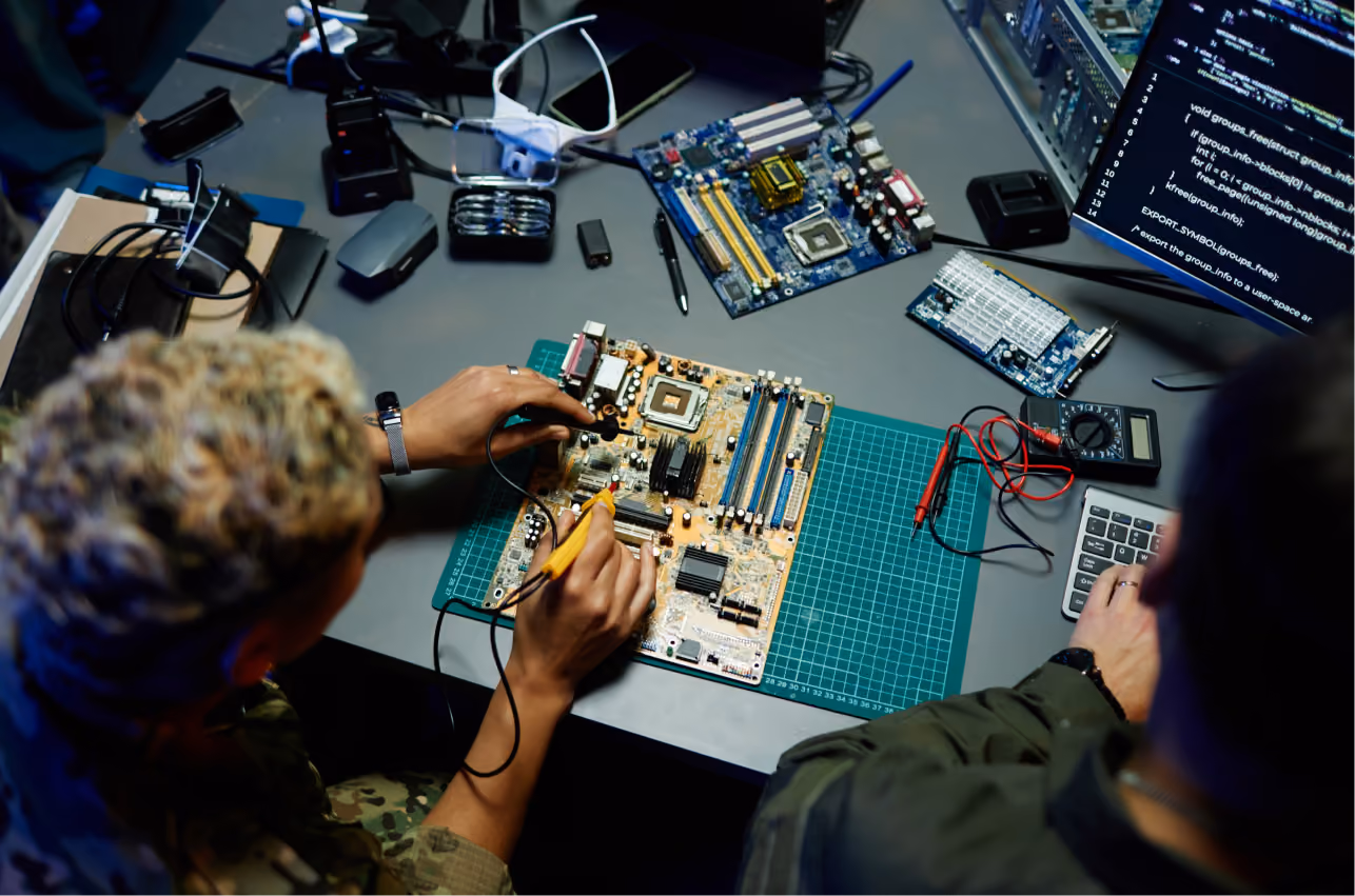 Engineers soldering a circuit board — engineering stage