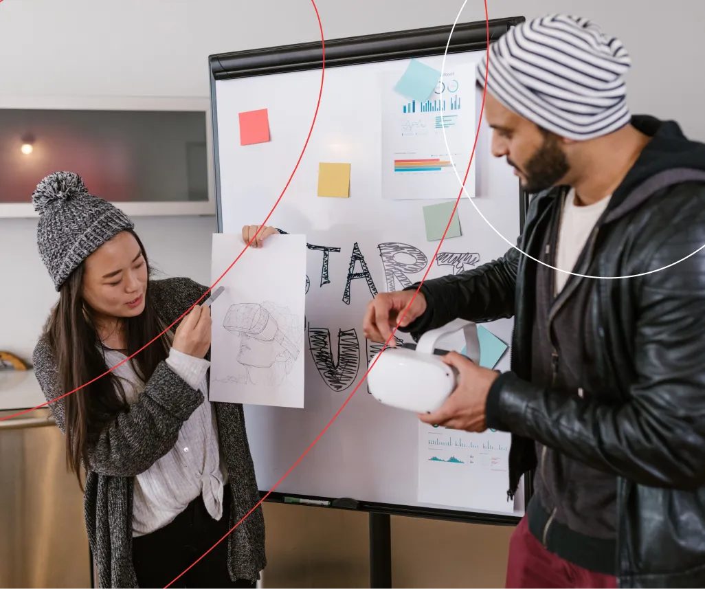Designers at a flipchart with VR headset sketches and a prototype — our purpose