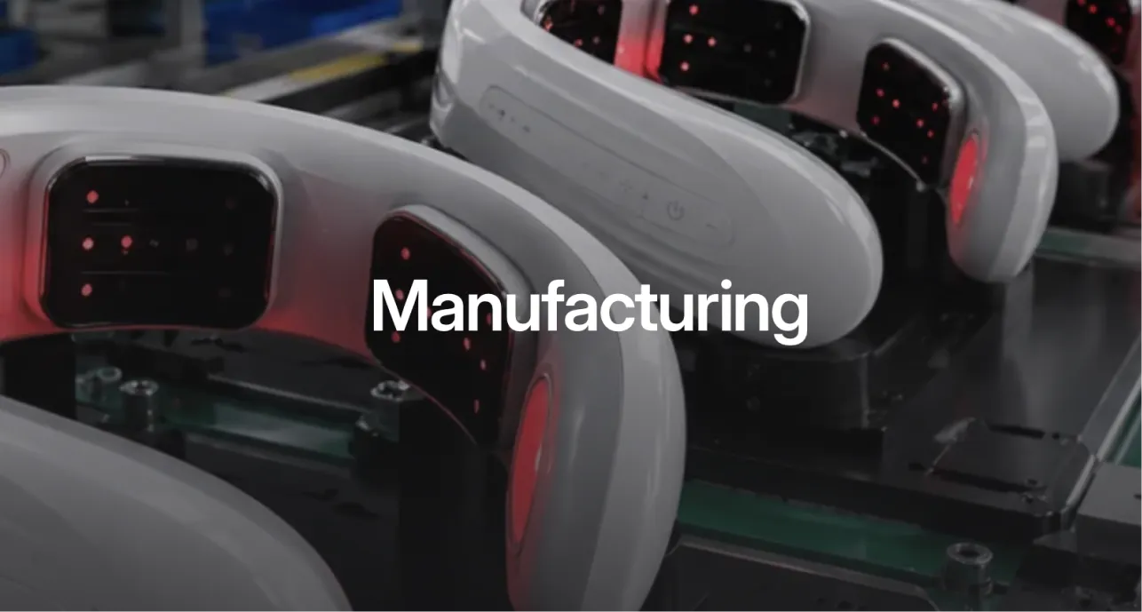 Neck massagers with red LED panels on a manufacturing line