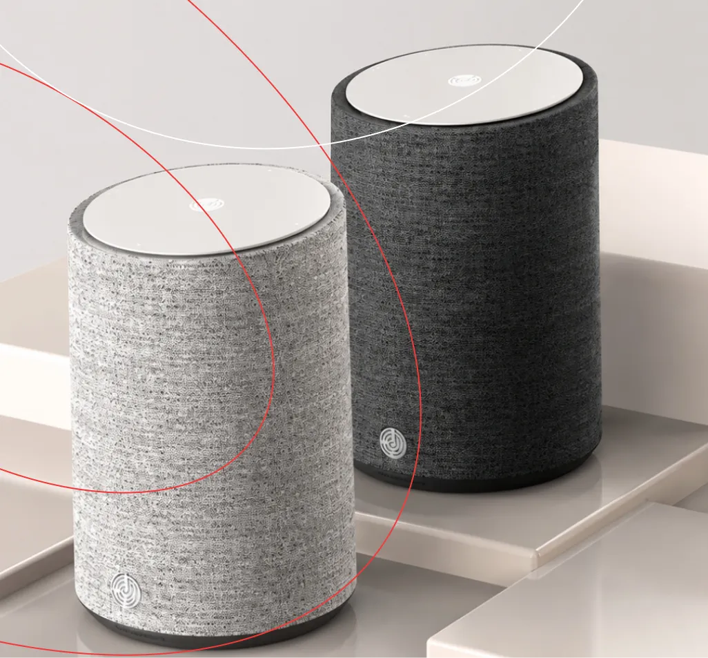 Two fabric-covered smart speakers, light grey and dark grey, on a white surface
