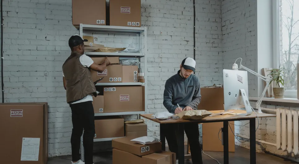 Two people packing and preparing product orders in a stockroom