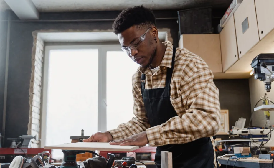 Young maker working on a piece at a workshop bench