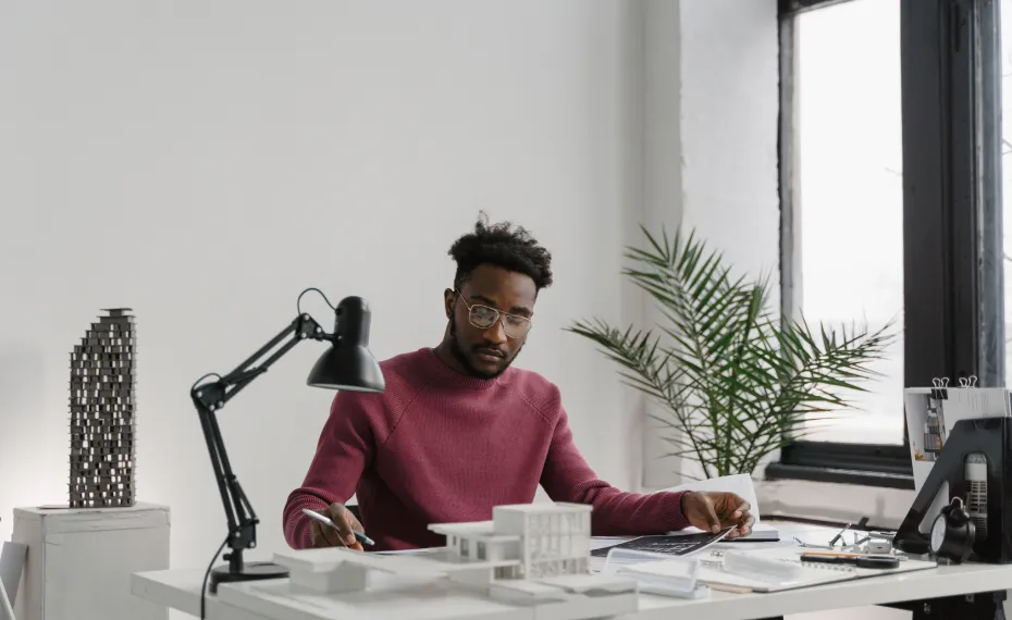 Designer working on an architectural model at his desk