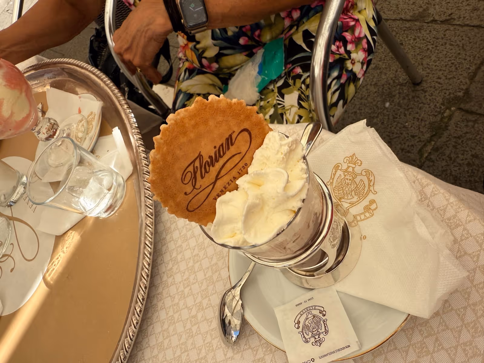 A hot chocolate with whipped cream and a cookie that says Florian Venezia