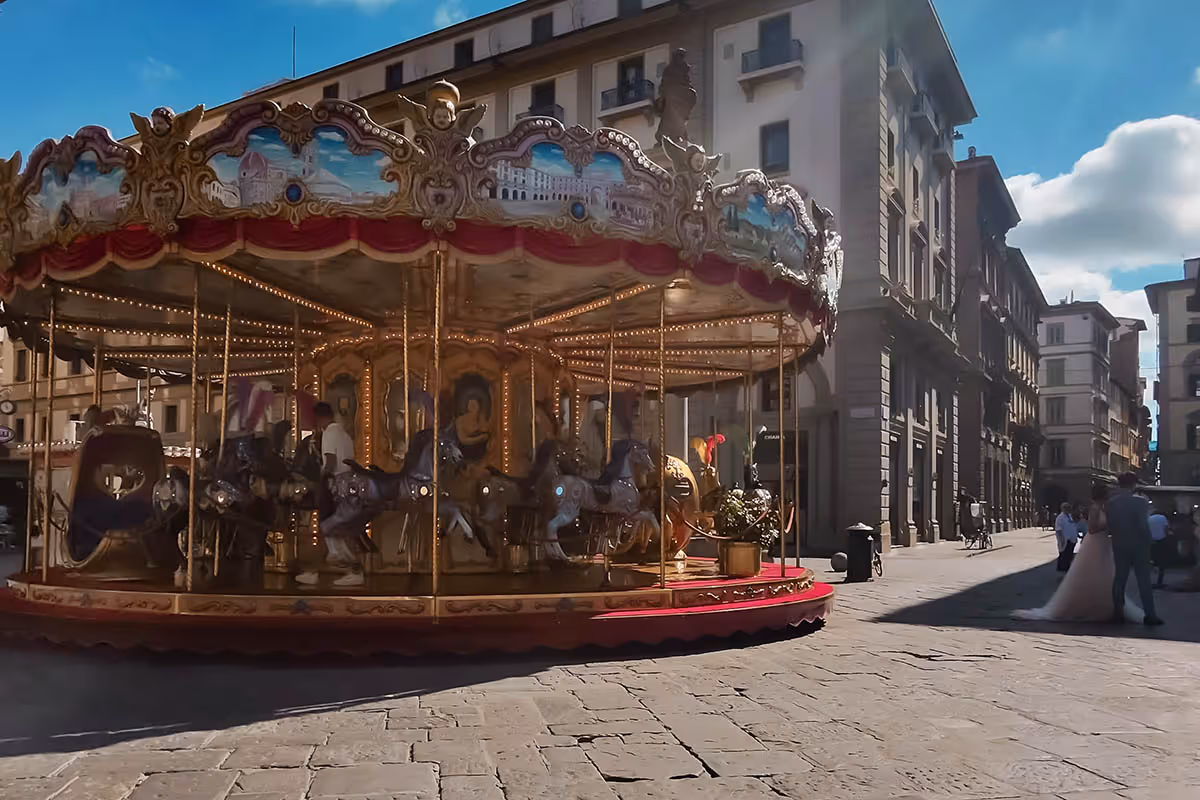 g vintage carousel in Piazza della Repubblica Florence with bride and groom posing for photo