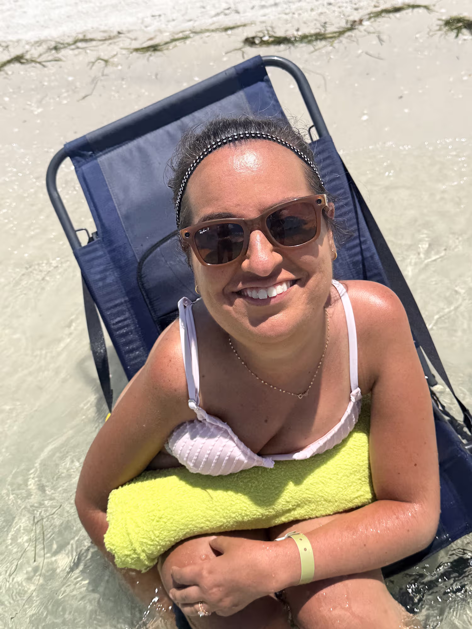 Power wheelchair user relaxing in a low beach chair in the clear water at Clearwater Beach