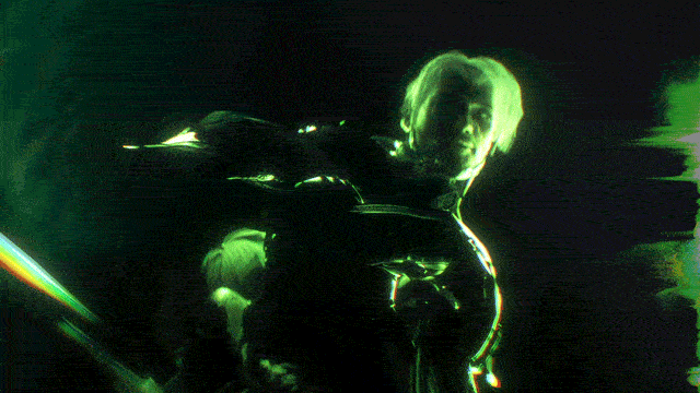 Animated figure with glowing green outlines in a dark environment, showing a close-up of a person with light-colored hair.