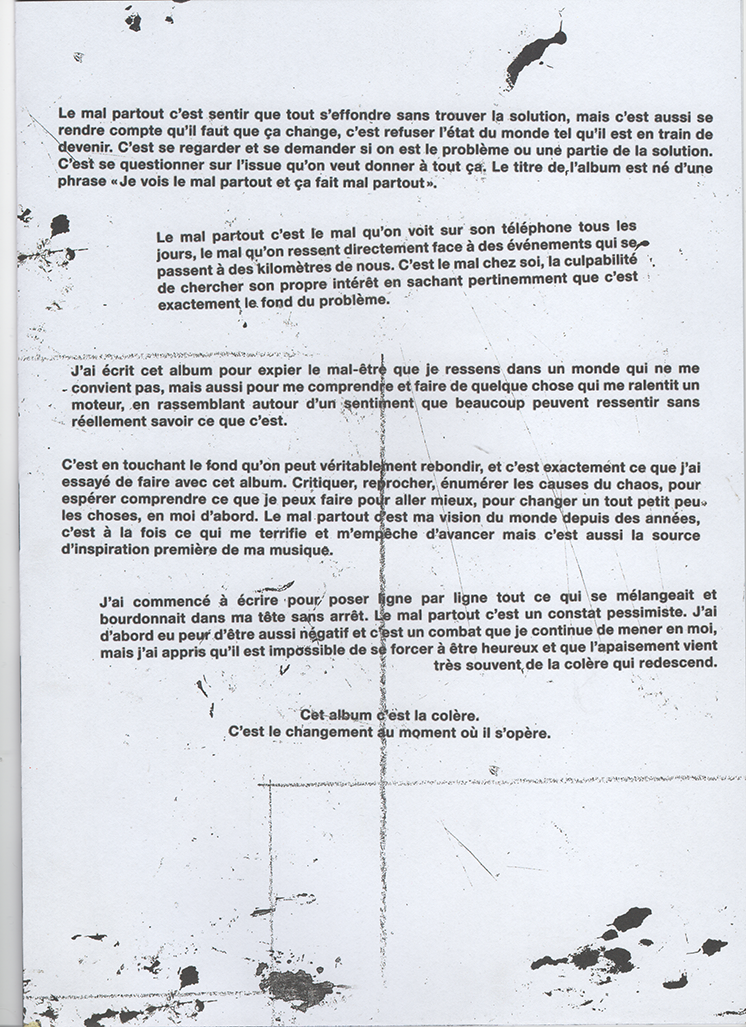 Sheet of paper with French text discussing themes of widespread suffering, personal reflection, and the emotional impact of an album titled 'Je vois le mal partout'.