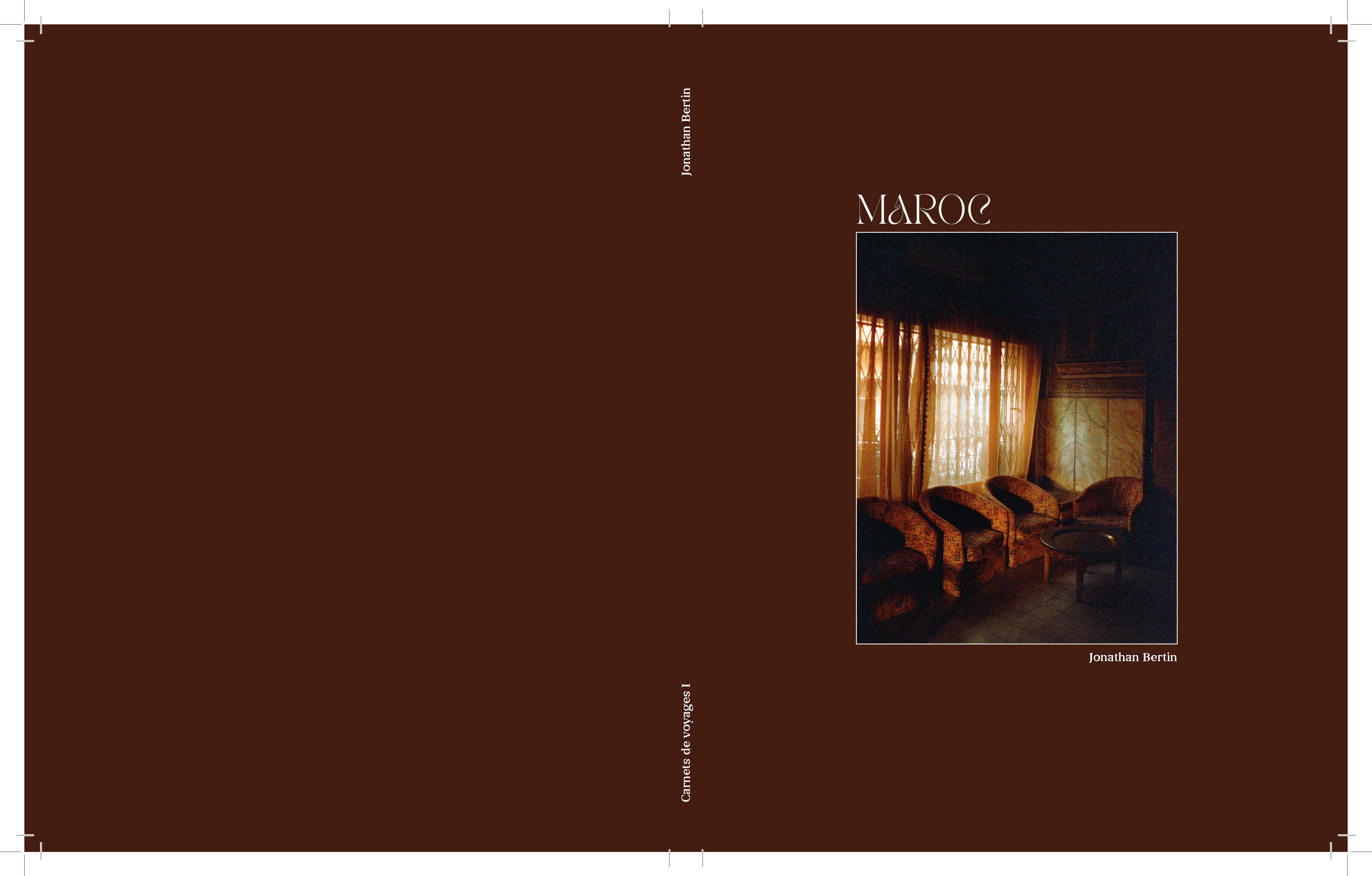 Book cover with brown background featuring a dimly lit room with patterned chairs and a round table by a window with sheer curtains.