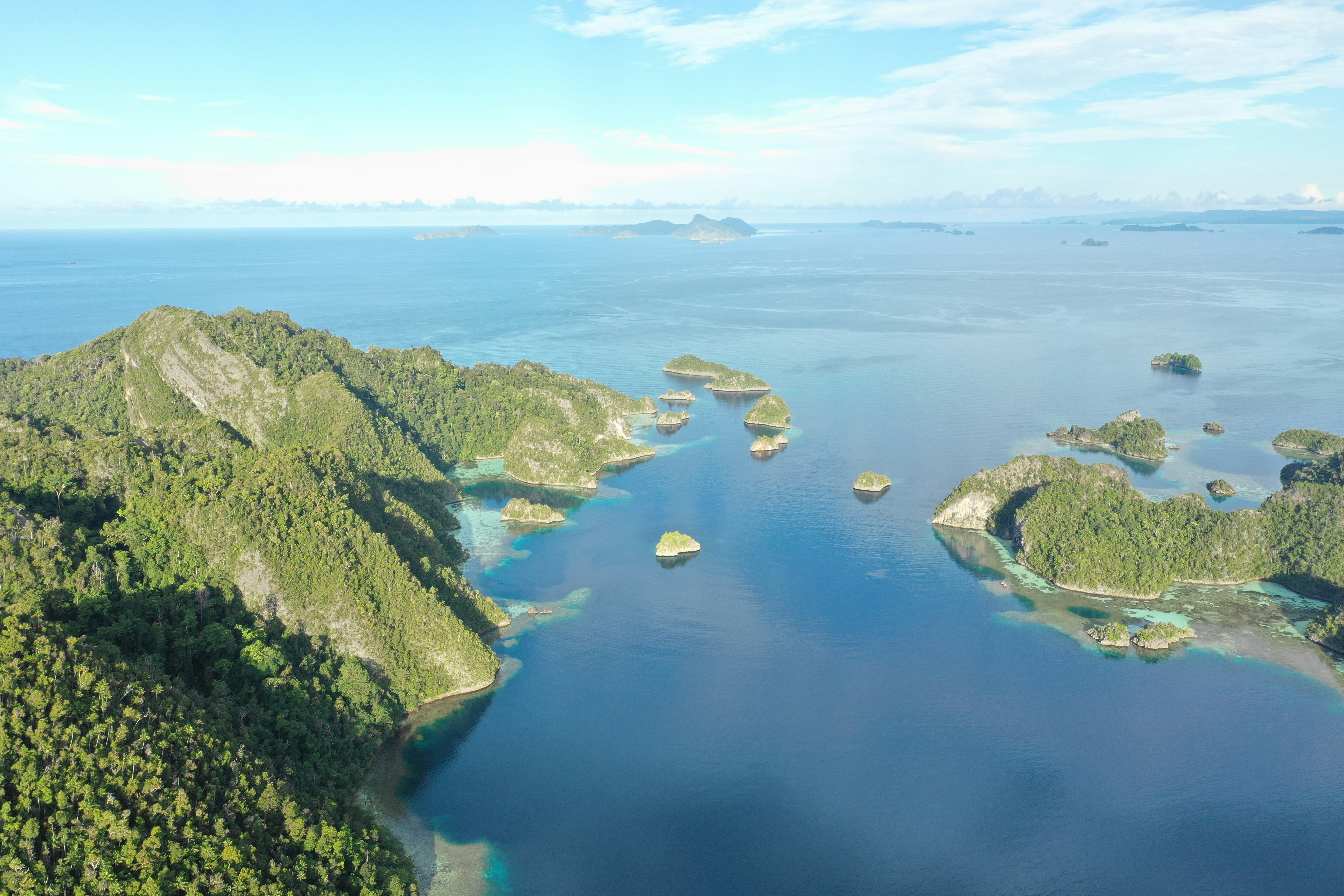 An aerial photo shows mountainous, green islands in blue body of water